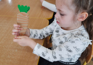 Dziewczynka wykonuje marchewkę z wełny