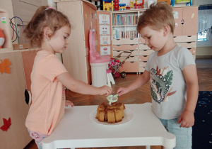 Dzieci posypują ciasto cukrem