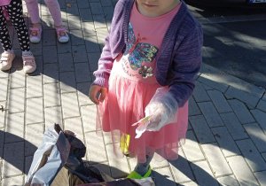 Dziewczynka wrzuca śmieci do worka