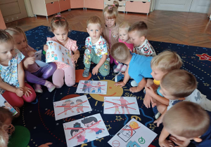 Dzieci oglądają plansze edukacyjne na temat ochrony małoletnich