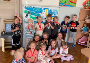 Dzieci pozują do zdjęcia z medalami