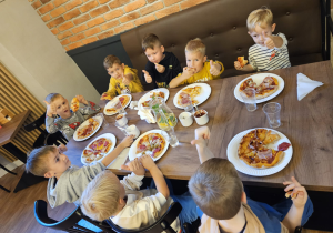 Dzieci jedzą pizzę