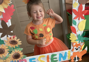Dziewczynka pozuje w jesiennej ramce