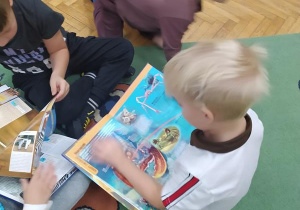 Dzieci oglądają książkę o zwierzętach