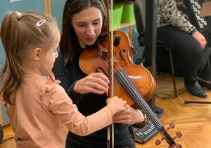 Dziewczynka próbuje grać na instrumencie