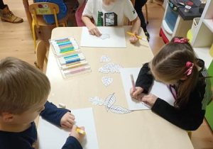Dzieci odbijają szablony liści za pomocą mazaków