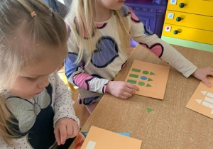 Dzieci układają wzory z figur geometrycznych