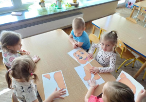 Dzieci układają puzzle z psem