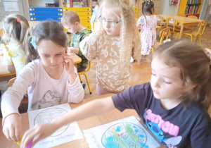 Dzieci za pomocą pipet i wody tworzą obrazki