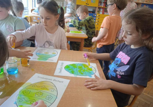 Dzieci za pomocą pipet i wody tworzą obrazki