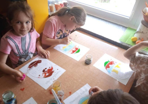 Dzieci za pomocą pipet i wody tworzą obrazki