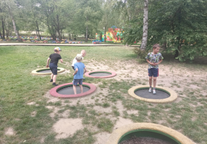 Dzieci skaczą na trampolinach