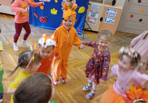 Dzieci tańczą w kole podczas balu jesieni