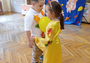 Dziewczynka z chłopczykiem tańcząc trzymając się za ręce