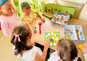 Dzieci wspólnie grają w grę planszową