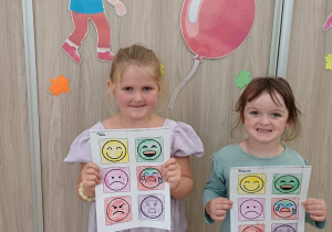 Dziewczynki pozują do zdjęcia z własnymi pracami