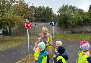 Dzieci wraz z nauczycielką oglądają i rozpoznają znaki drogowe