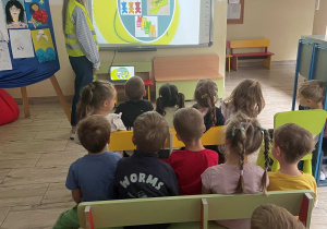 Dzieci słuchają nauczycielki podczas zajęć z okazji Dnia Odblasku