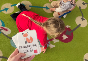 Dziewczynka naśladuje skradającego się lisa