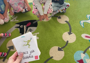 Dziewczynka naśladuje skaczącą żabkę