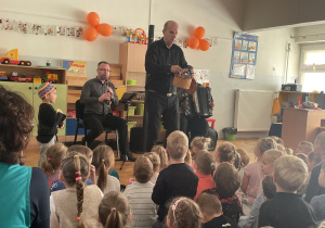 Chłopiec gra na instrumencie, a Pan Michał pokazuje węża