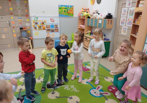 Dzieci przekazują sobie z rąk do rąk pomarańcze