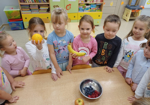 Dzieci pokazują owoce, które będą próbowały