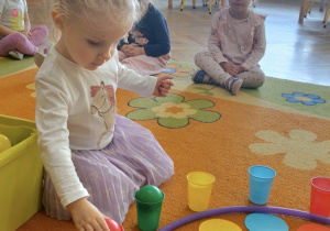 Dziewczynka uczestniczy w zabawie na dywanie