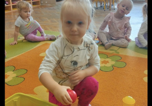 Dziewczynka uczestniczy w zabawie na dywanie