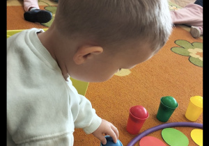 Chłopiec uczestniczy w zabawie na dywanie