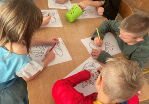 Dzieci wykonują prace plastyczną "Pinokio"