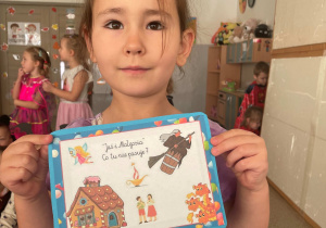 Dziewczynka pozuje z plansza do zdjęcia