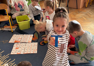 Dziewczynka tworzy literkę T z klocków