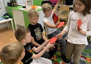 Dziewczynka rozdaje czerwone koła