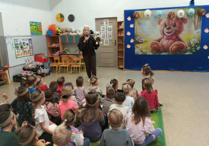 Nauczycielka z misiem wita dzieci