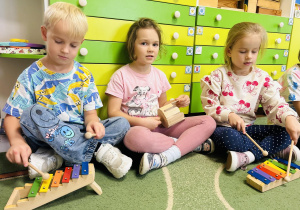 Troje dzieci gra na instrumentach