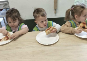 Dzieci jedzą pizzę