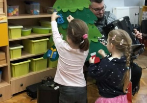 Dzieci dekorują choinkę