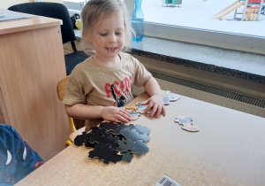Chłopiec układa puzzle
