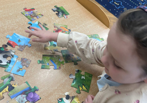 Dziewczynka układa puzzle
