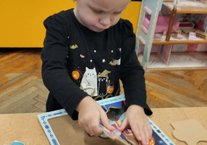 Dziewczynka układa puzzle