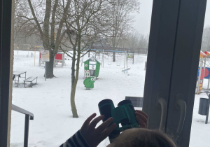 Dziewczynka wypatruje ptaków przez lornetkę