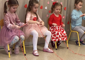 Dzieci zwijają wstążkę biorąc udział w zabawie