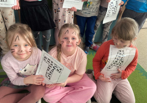 Dzieci pozują do wspólnego zdjęcia z okazji Dnia Kota