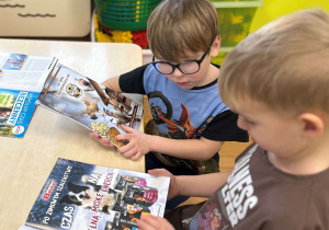 Dzieci oglądają gazety o zwierzętach