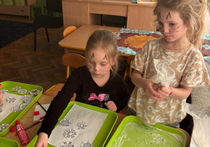 Dziewczynki przygotowują pracę plastyczną z wykorzystaniem materiałów sensorycznych