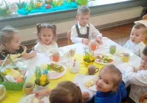 Dzieci jedzą wspólne śniadanie