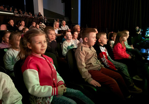 Dzieci oglądają z zaciekawieniem przedstawienie teatralne