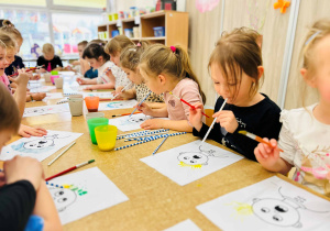 Dzieci wykonują pracę plastyczną- używając farb, słomek i pędzelków