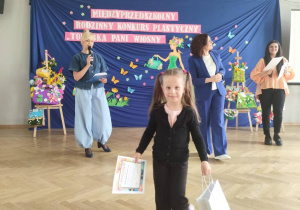 Dziewczynka odbiera nagrodę